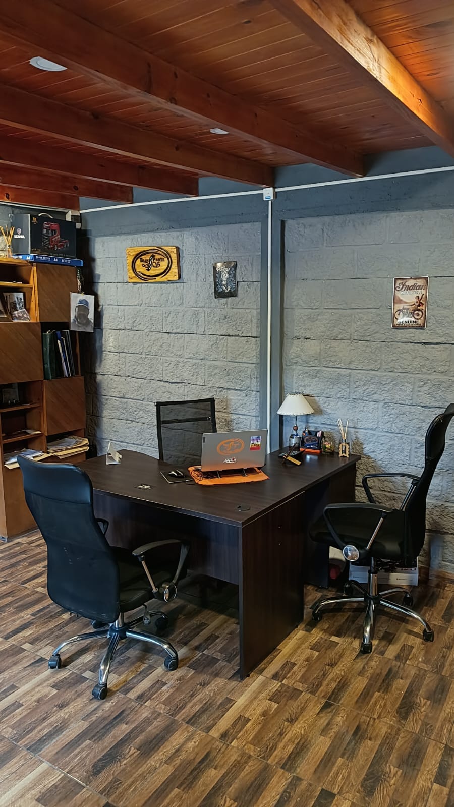 Oficina de Transporte DS: escritorio, sillas y la placa de madera con el logo en la pared
